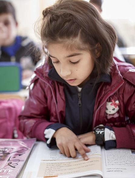 Ein syrisches Mädchen liest in einem Schulbuch. (quelle: Jakob Studnar)