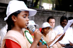 Ein indisches Mädchen aus einem Kinderparlament spricht in ein Mikrofon. (Quelle: Kindernothilfe-Partner)