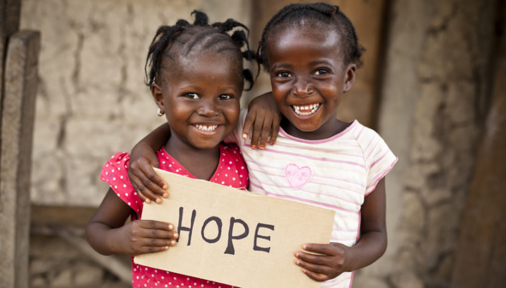 Zwei kenianische Mädchen halten ein Schild mit dem Wort "Hope". (Quelle: MShep2/iStock)